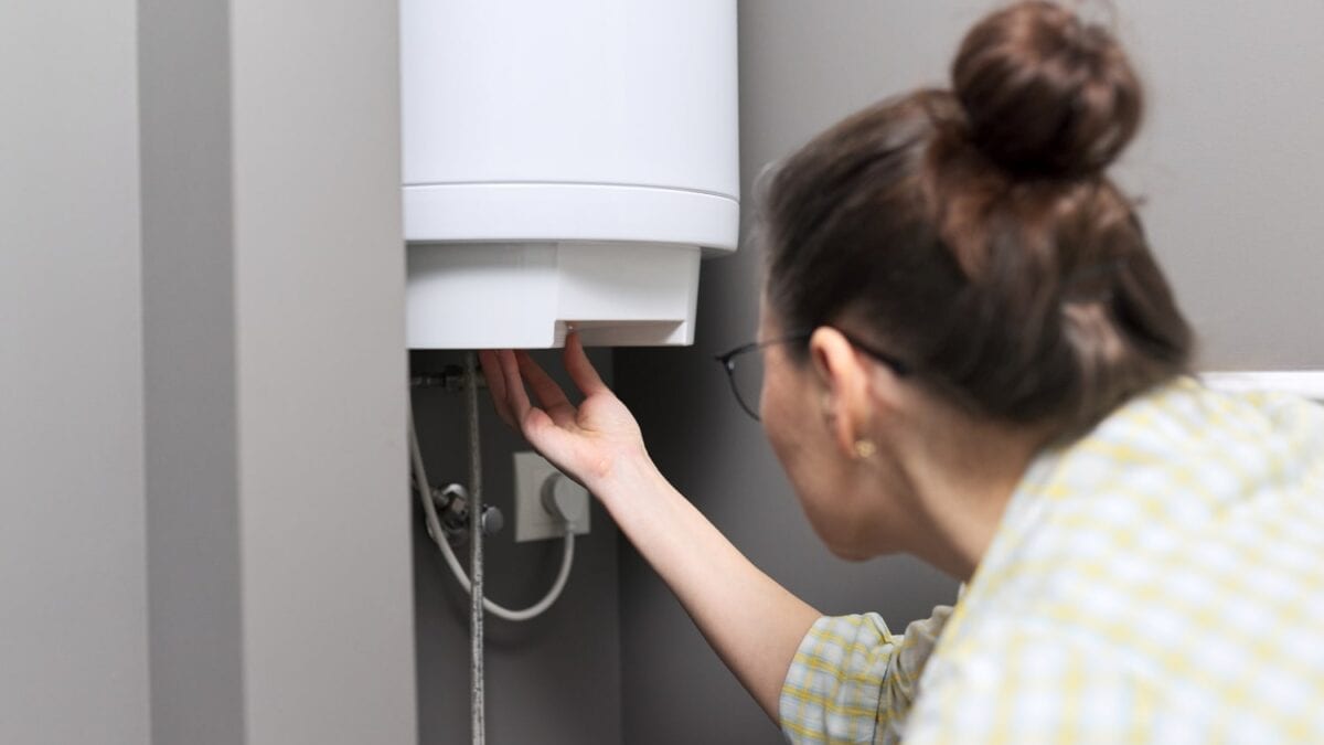 A woman adjusting settings on a wall-mounted boiler during essential maintenance.