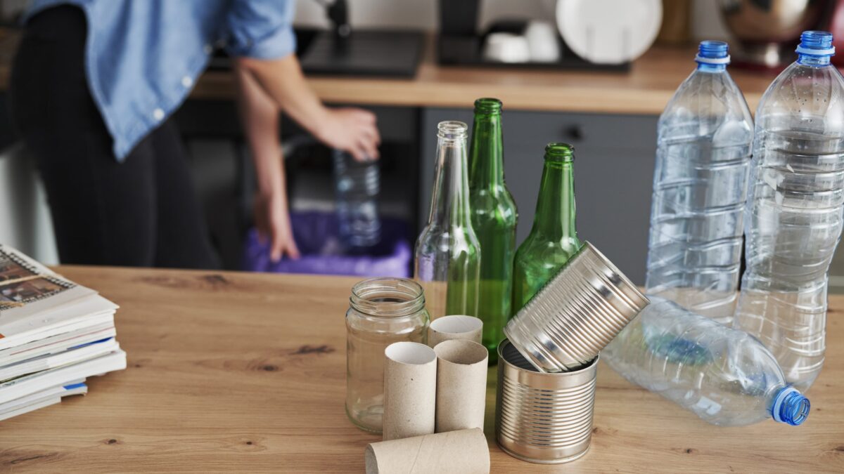 Recycling assorted household waste on a wooden table with noisy garbage disposals humming in the background.