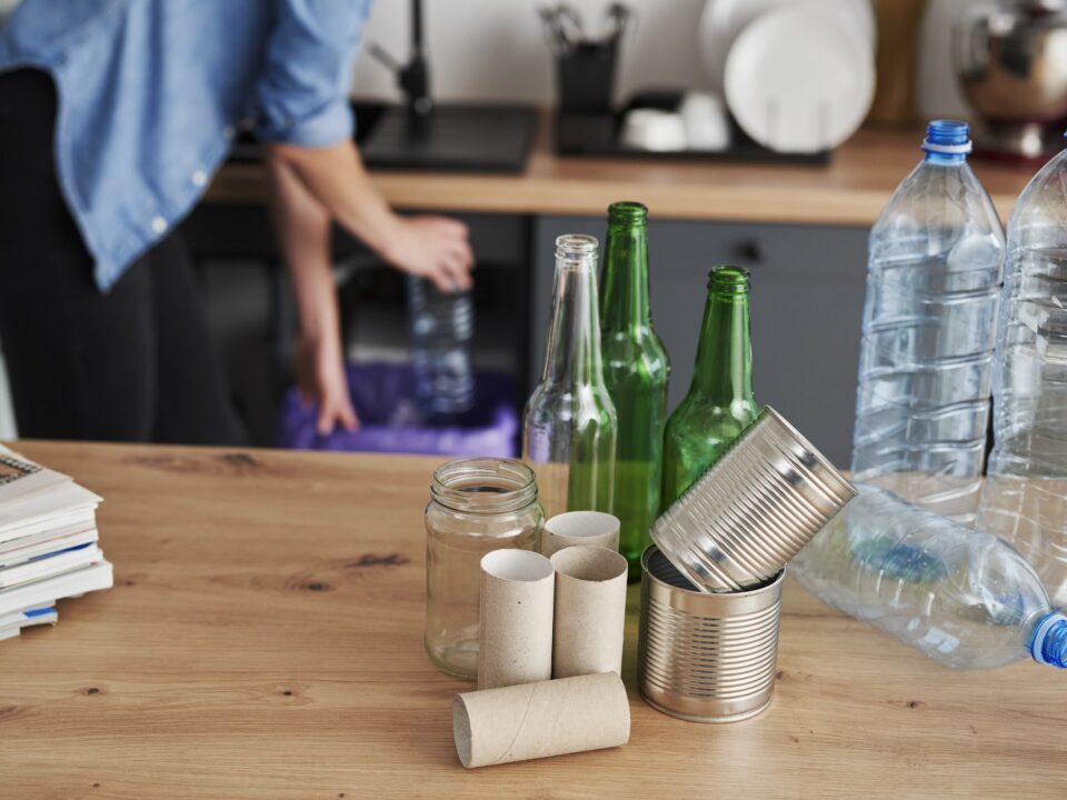 Recycling assorted household waste on a wooden table with noisy garbage disposals humming in the background.